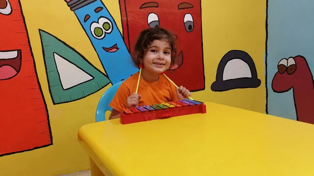 Young child playing xylophone — early music exploration